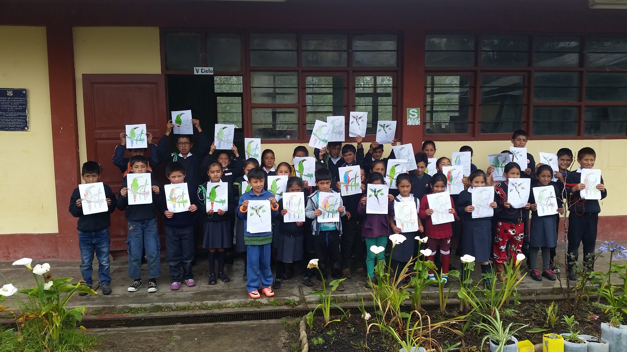 group of children holding bird drawings